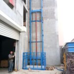 Guide rail cargo lift mounted against a wall